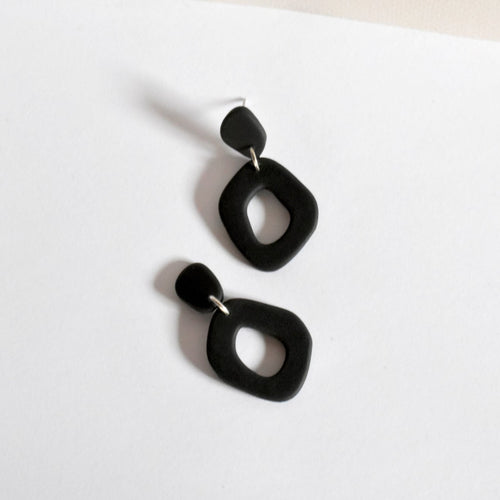 Matte black organic shape hoop earrings handmade from polymer clay.