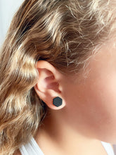 Load image into Gallery viewer, Model wearing a 10mm hexagon stud earings in black for size reference.
